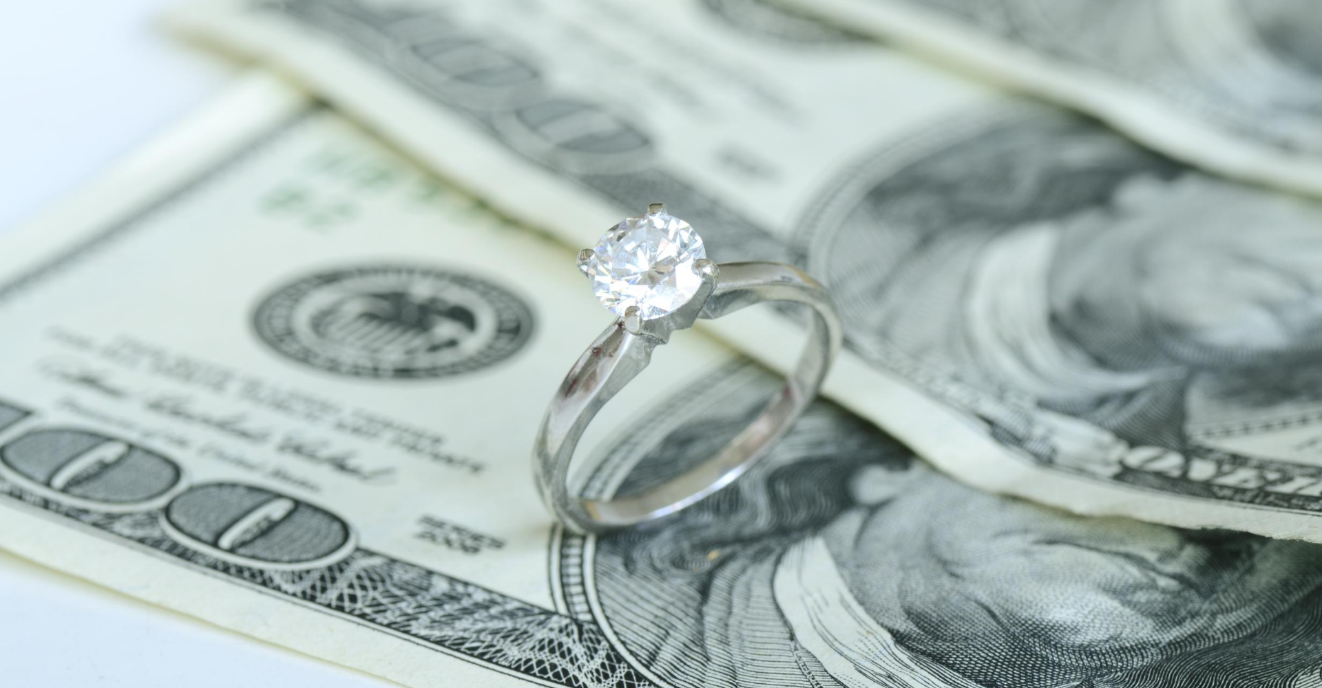 wedding ring on 100 dollar bills