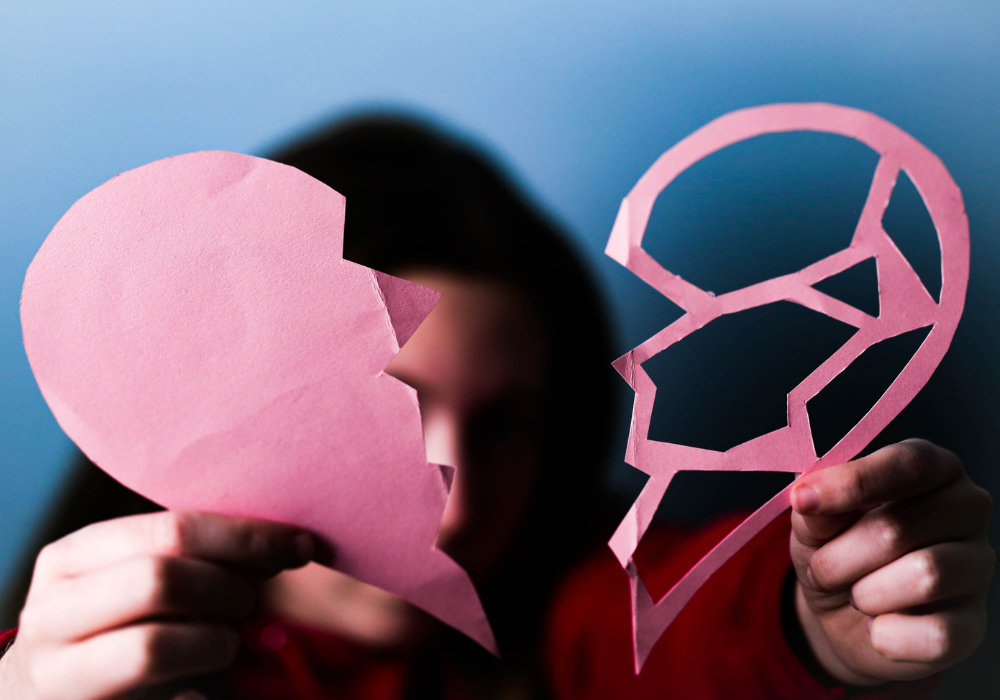 woman holding ripped paper heart